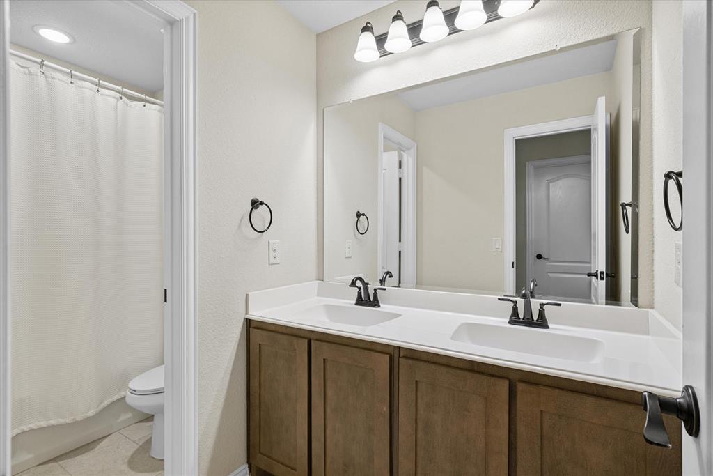 4102 Sublett Way Kaufman, TX 75142 - Photo 24 of 40 Full bath featuring double vanity, tile patterned floors, and a shower with shower curtain