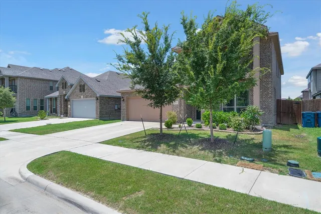 a view of a house with a big yard plants and large trees