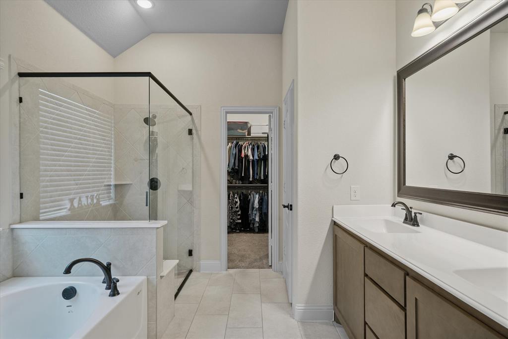 4102 Sublett Way Kaufman, TX 75142 - Photo 32 of 40 Full bath with a shower stall, a bath, double vanity, a spacious closet, and vaulted ceiling