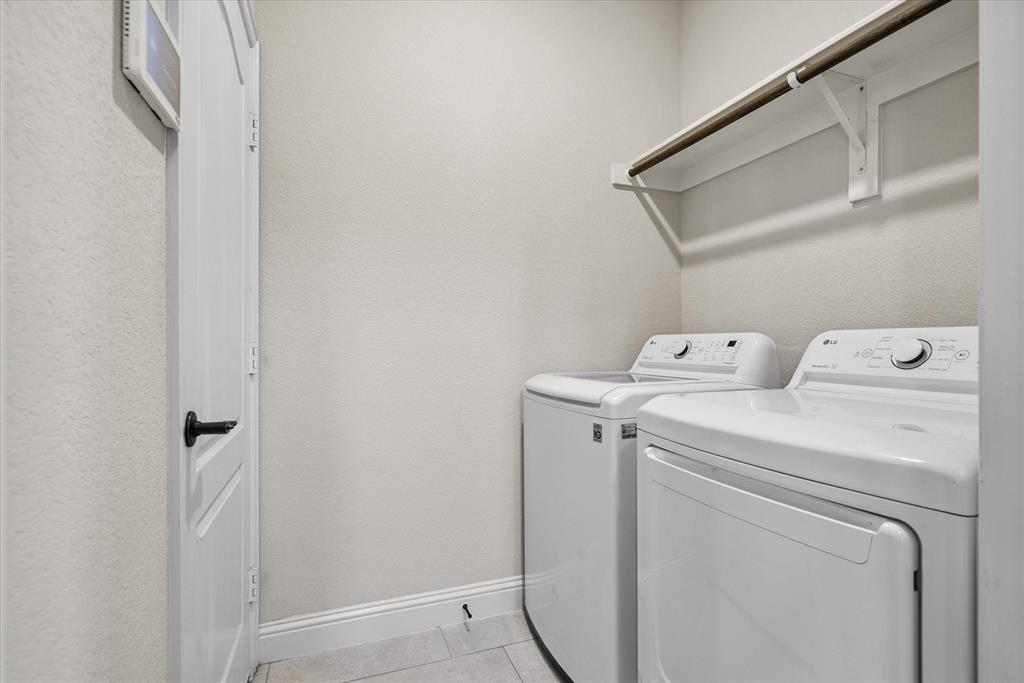 4102 Sublett Way Kaufman, TX 75142 - Photo 35 of 40 Washroom featuring washing machine and clothes dryer and light tile patterned floors