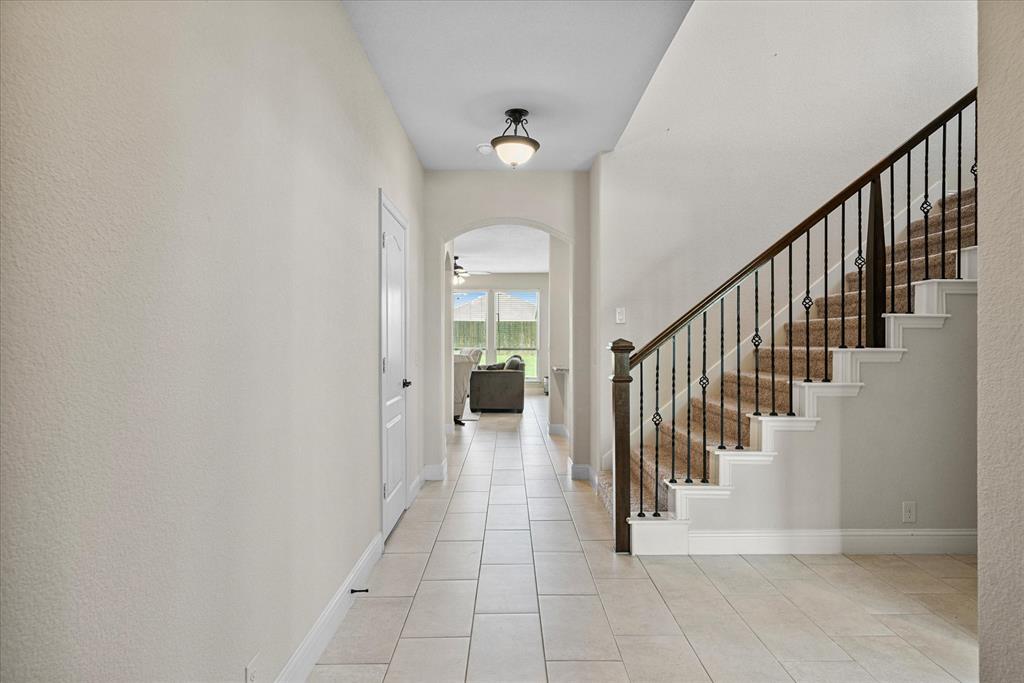 4102 Sublett Way Kaufman, TX 75142 - Photo 5 of 40 Entrance foyer with arched walkways, light tile patterned flooring, stairs, and ceiling fan