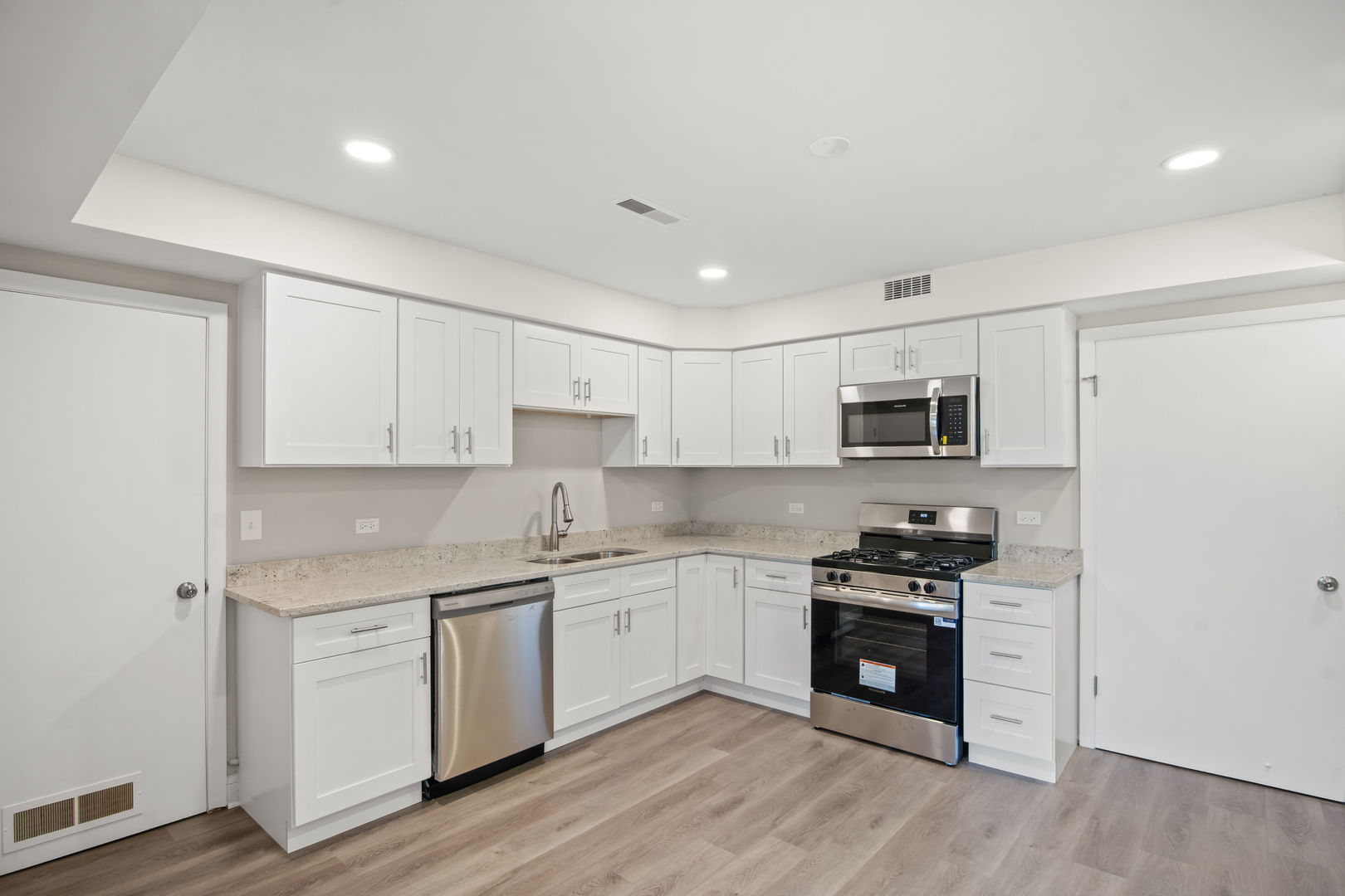 914 Brook Street Elgin, IL 60120 - Photo 13 of 21 a kitchen with stainless steel appliances white cabinets and wooden floor