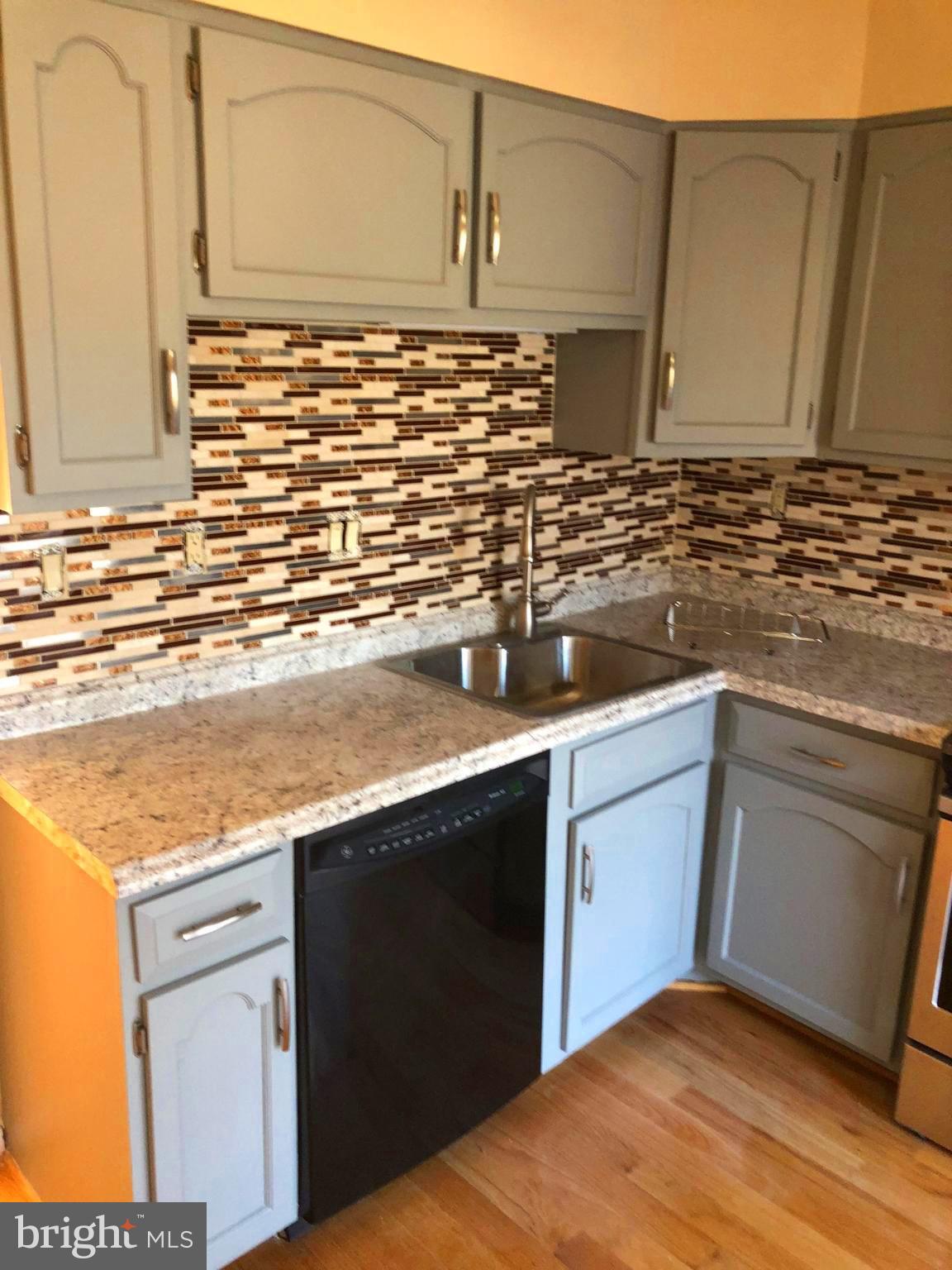 1634 Valencia Way Reston, VA 20190 - Photo 8 of 29 a kitchen with granite countertop cabinets sink and white appliances