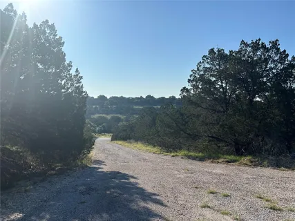 a view of a road with a trees in the background