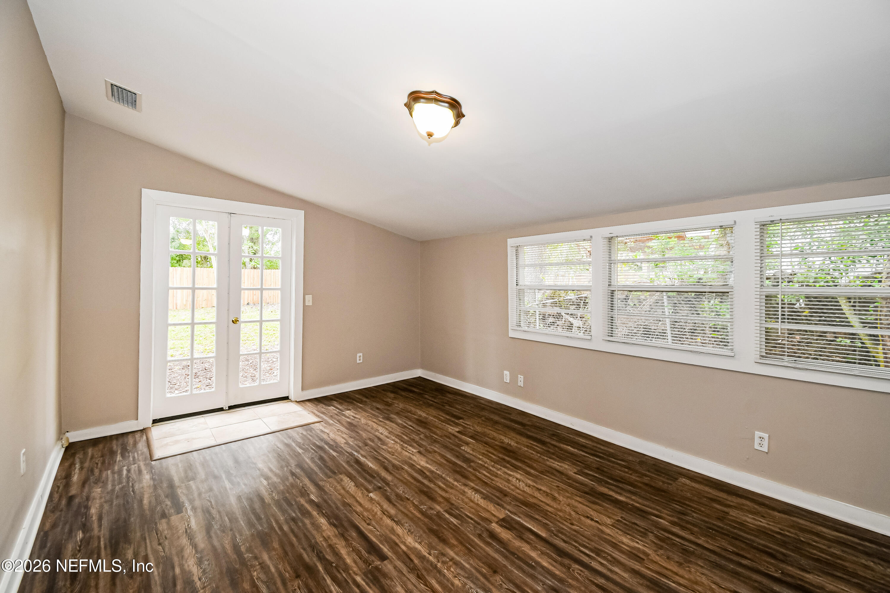 7227 Stonehurst Road North Jacksonville, FL 32277 - Photo 8 of 16 a view of an empty room with wooden floor and a window