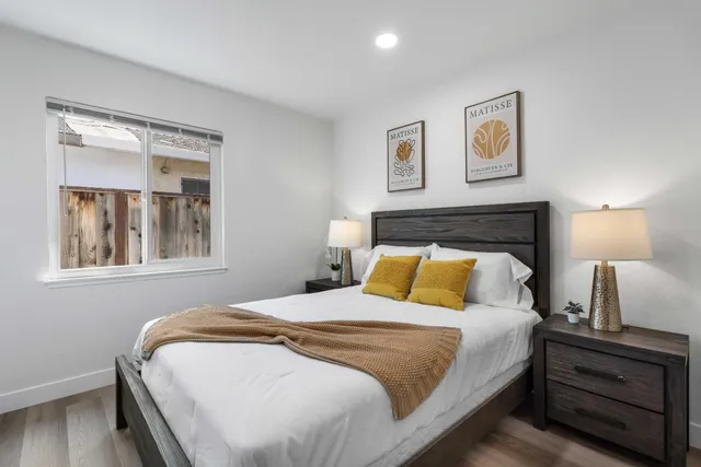 a bedroom with a bed and a painting on the wall