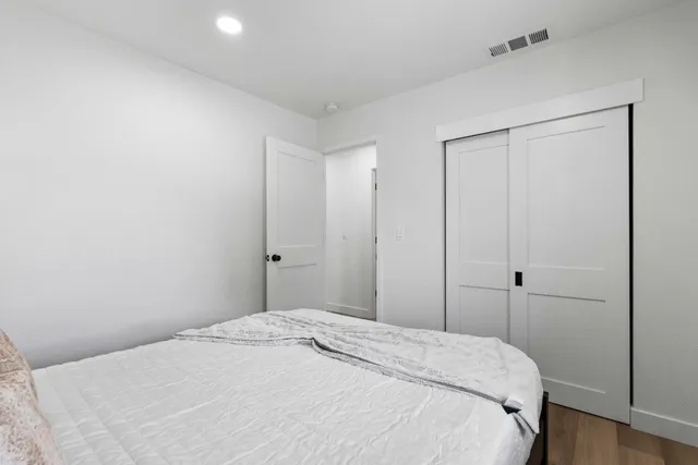 a bedroom with a bed and wooden floor