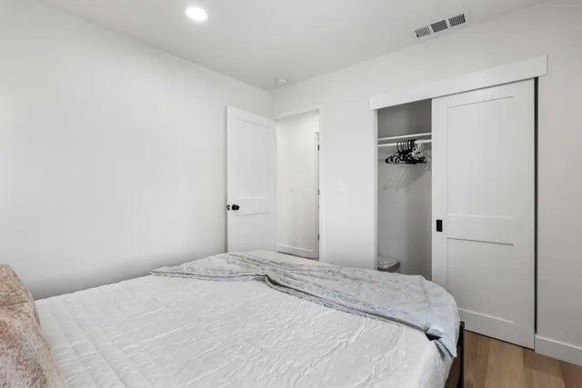 a bedroom with a bed and a wooden floor