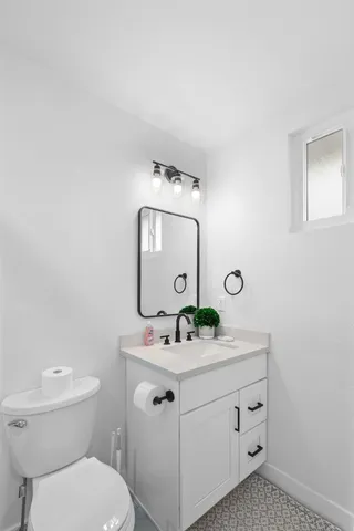 a bathroom with a toilet sink and mirror