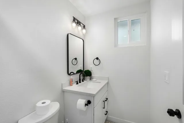 a bathroom with a sink a toilet and mirror