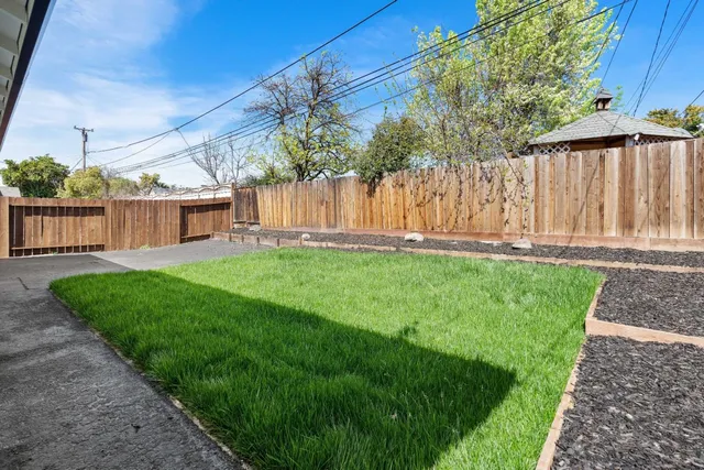 a view of a house with a yard and sitting area