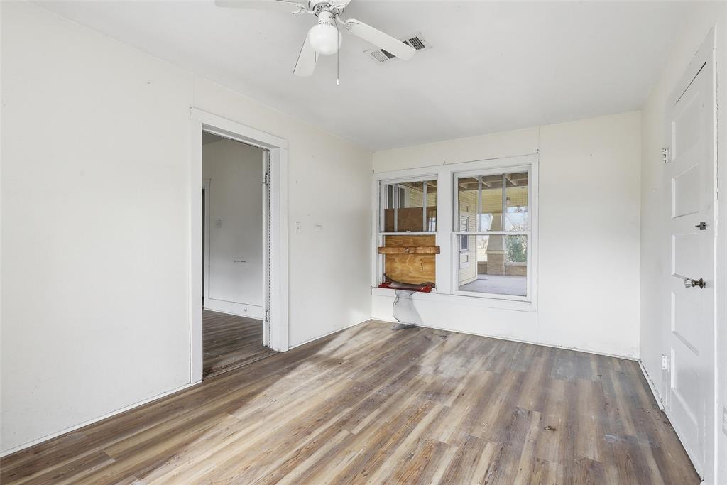 403 East Morgan Street Meridian, TX 76665 - Photo 24 of 40 an empty room with wooden floor and windows