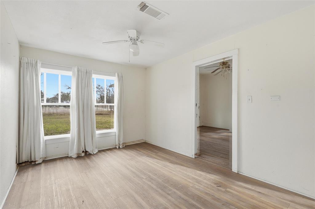 403 East Morgan Street Meridian, TX 76665 - Photo 25 of 40 an empty room with wooden floor cabinet and windows