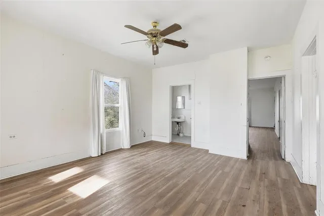 a view of empty room with wooden floor and window