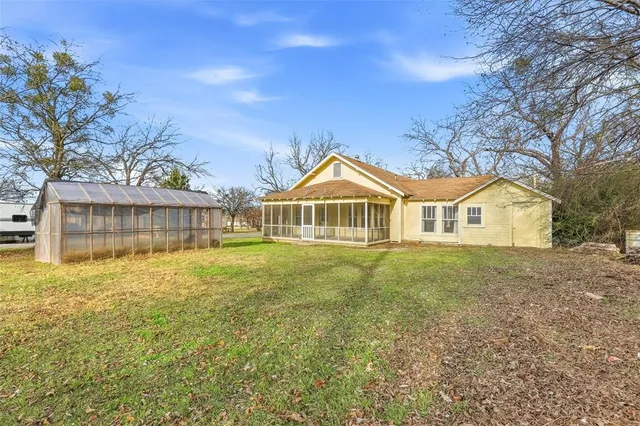 a view of a house with a yard and potted plants