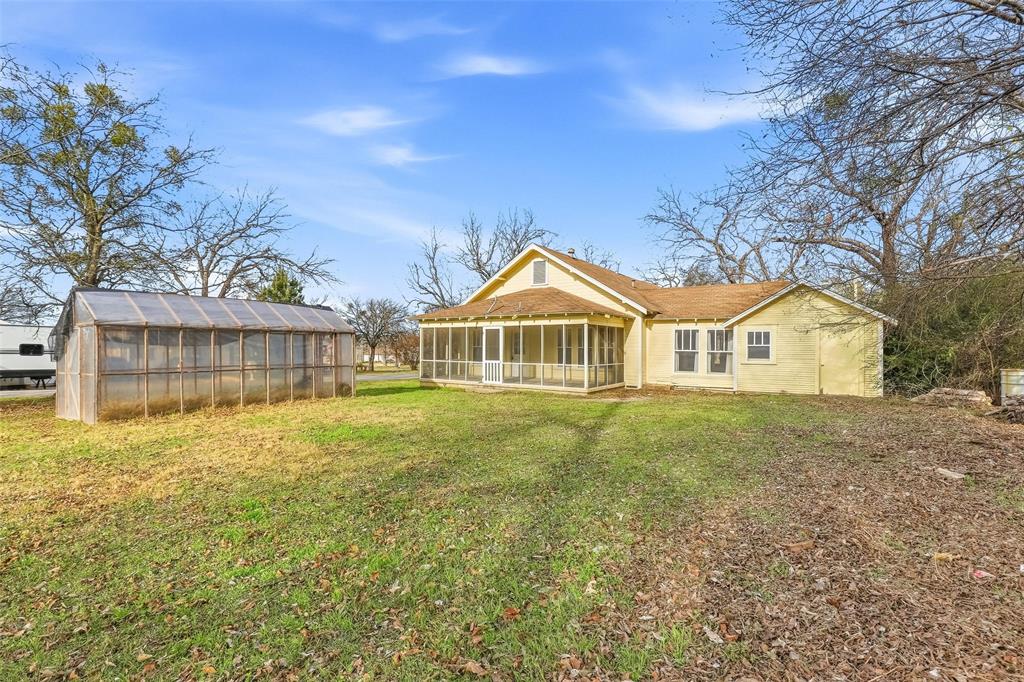 403 East Morgan Street Meridian, TX 76665 - Photo 4 of 40 a view of a house with a yard and potted plants