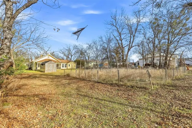 a view of a yard with wooden fence