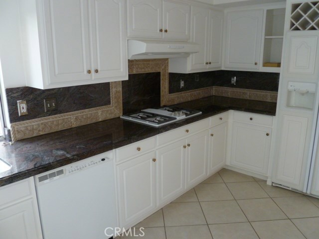 48 Cedar Tree Lane Irvine, CA 92612 - Photo 12 of 52 a kitchen with granite countertop white cabinets and black appliances