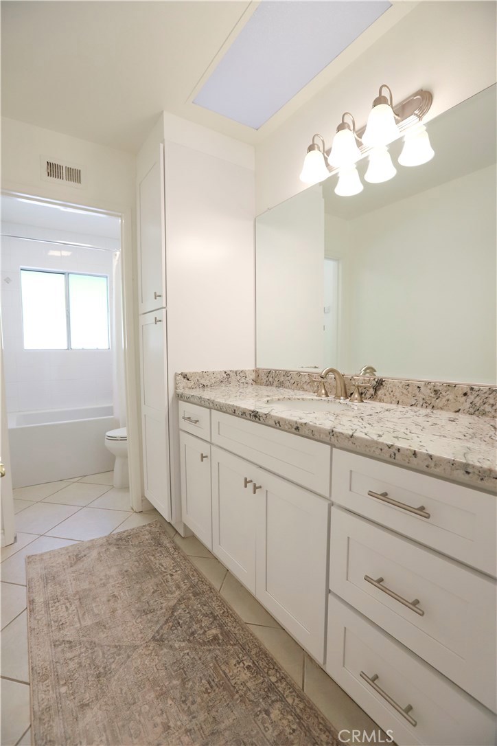 48 Cedar Tree Lane Irvine, CA 92612 - Photo 22 of 52 a bathroom with a granite countertop sink a mirror and a vanity