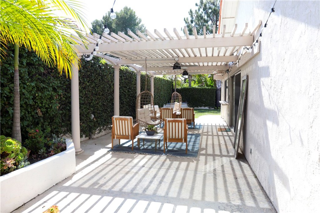 48 Cedar Tree Lane Irvine, CA 92612 - Photo 30 of 52 a view of a patio with table and chairs potted plants with wooden floor and fence