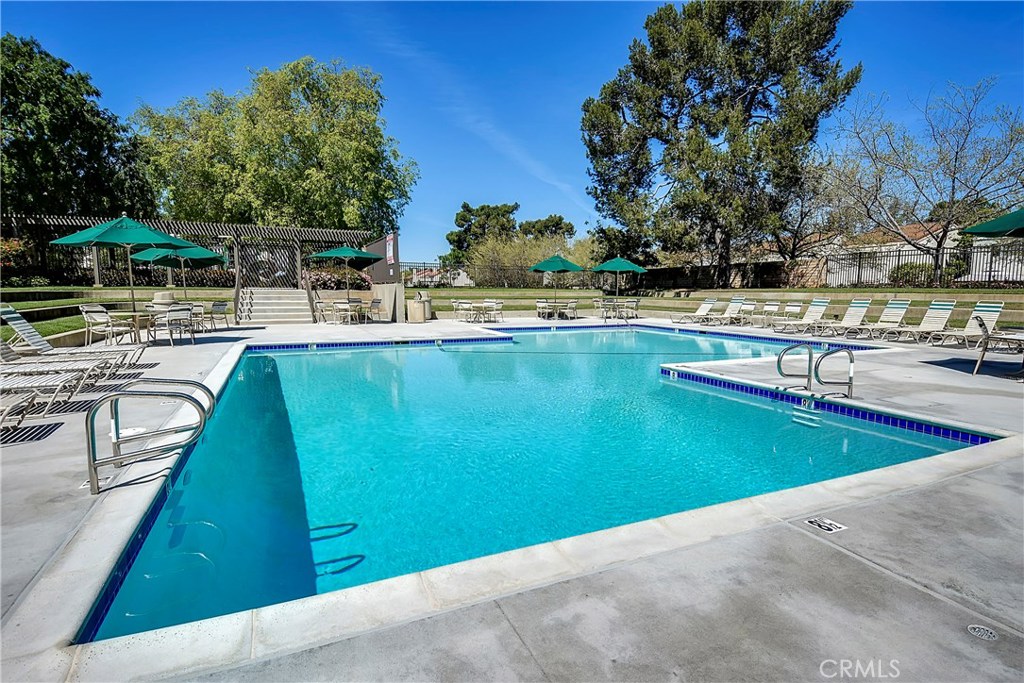 48 Cedar Tree Lane Irvine, CA 92612 - Photo 40 of 52 a view of a swimming pool with a table and chairs