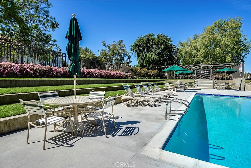 48 Cedar Tree Lane Irvine, CA 92612 - Photo 41 of 52 a view of a swimming pool with a table and chairs
