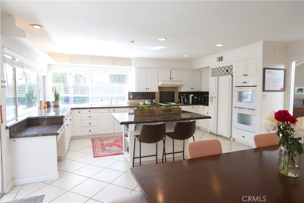 48 Cedar Tree Lane Irvine, CA 92612 - Photo 5 of 52 a kitchen with stainless steel appliances kitchen island granite countertop a refrigerator and a sink