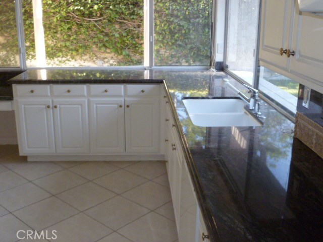48 Cedar Tree Lane Irvine, CA 92612 - Photo 7 of 52 a view of a kitchen with a sink a window and wooden floor
