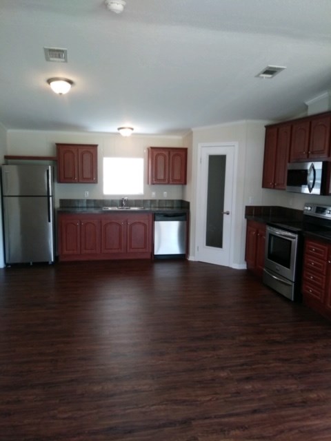 13465 Yellow Bluff Road Jacksonville, FL 32226 - Photo 11 of 30 a kitchen with stainless steel appliances wooden cabinets and a wooden floor
