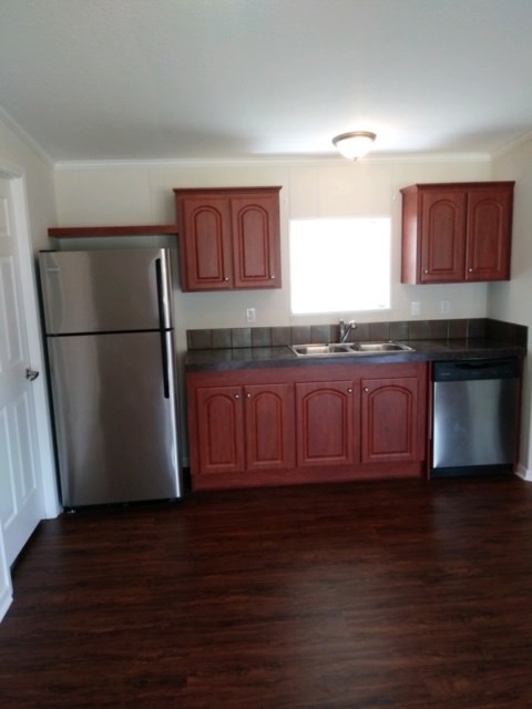 13465 Yellow Bluff Road Jacksonville, FL 32226 - Photo 10 of 30 a kitchen with granite countertop a refrigerator a sink and wooden cabinets