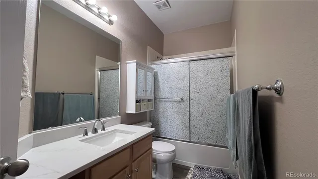a bathroom with a double vanity sink toilet and shower