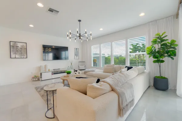 a living room with furniture potted plant and a flat screen tv