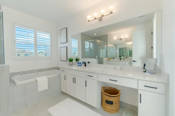 a spacious bathroom with a granite countertop sink mirror and bathtub