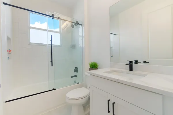 a bathroom with a sink a toilet and shower