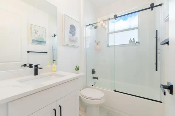 a bathroom with a sink a toilet and shower