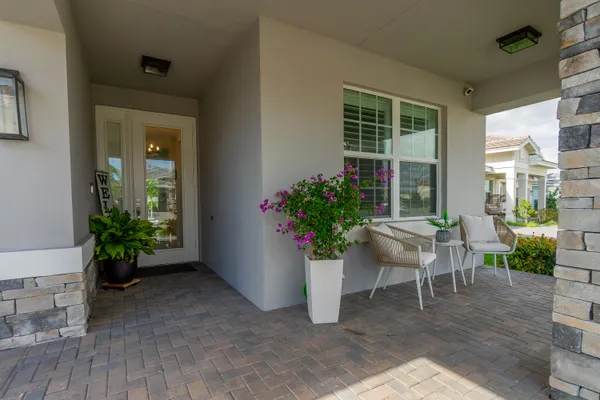 a view of a porch with chairs and potted plants