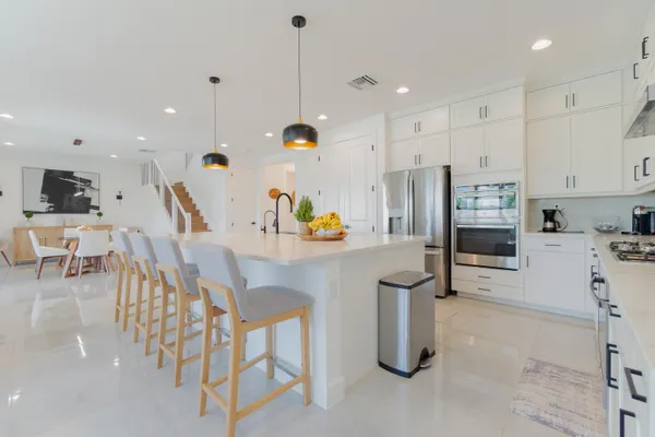 a kitchen with stainless steel appliances refrigerator microwave and white cabinets