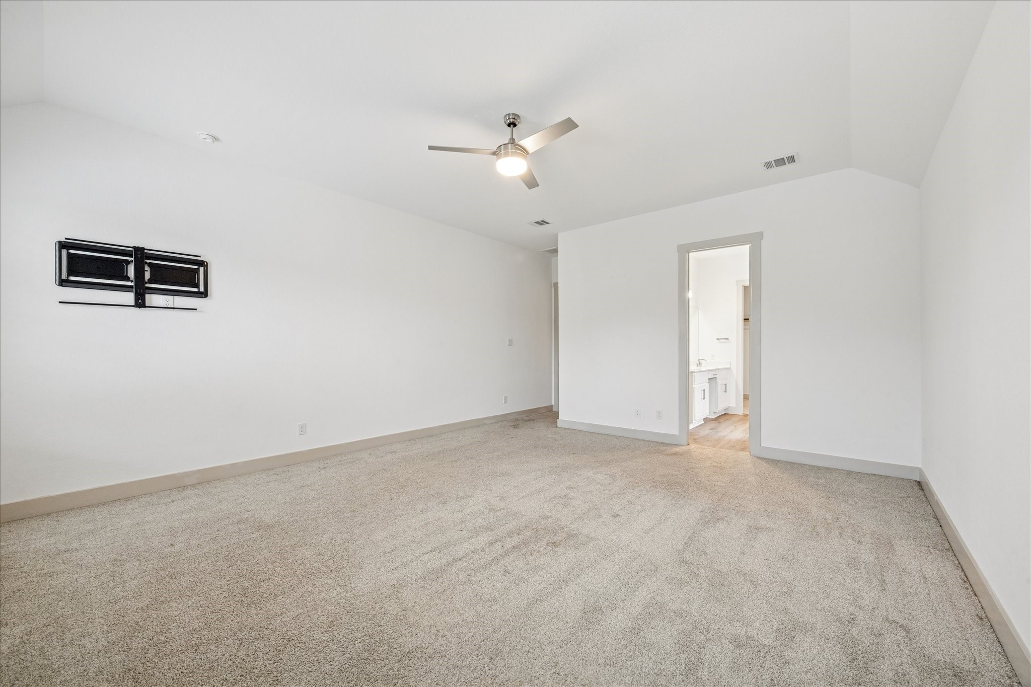 2550 Austin Trail Friendswood, TX 77546 - Photo 17 of 35 Another view of the primary suite with a tv wall mount and entry to the en-suite bathroom.