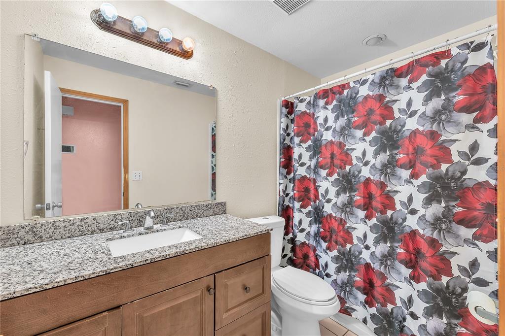 3420 Yale Circle Riverview, FL 33578 - Photo 16 of 30 a bathroom with a granite countertop sink a toilet and a mirror