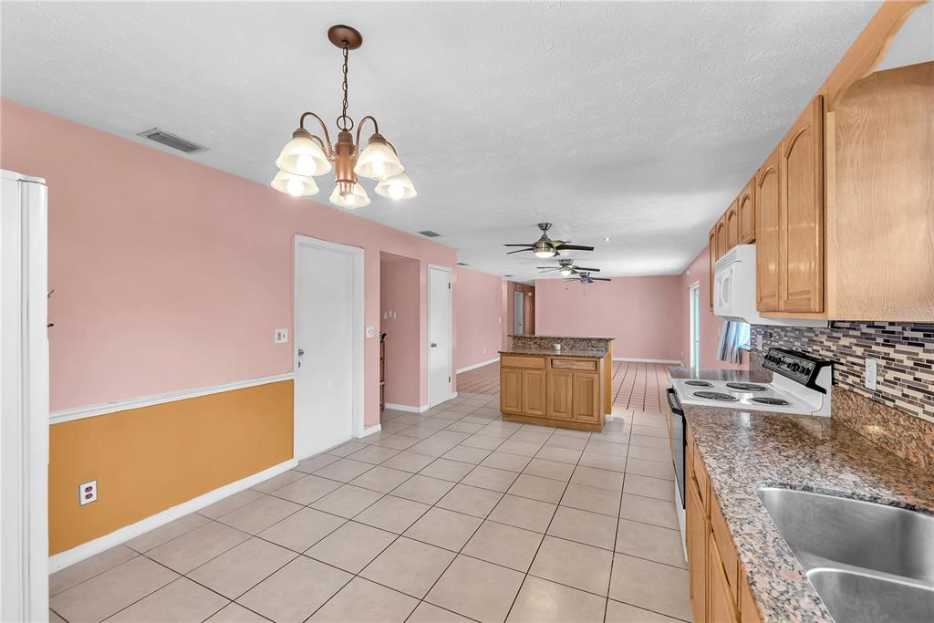 3420 Yale Circle Riverview, FL 33578 - Photo 9 of 30 a kitchen with kitchen island granite countertop a stove a sink a counter space and cabinets