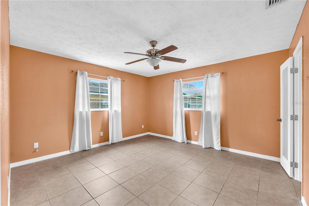 3420 Yale Circle Riverview, FL 33578 - Photo 10 of 30 an empty room with chandelier fan and windows