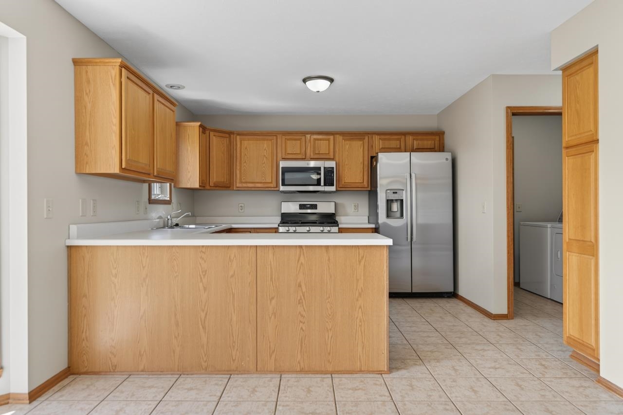 676 Elberon Way Roscoe, IL 61073 - Photo 10 of 30 a kitchen with stainless steel appliances granite countertop a refrigerator and a stove top oven