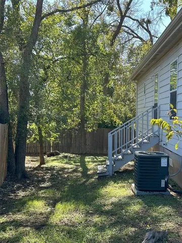 a view of a backyard with a small cabin and wooden fence