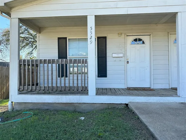 a view of a house with a small yard and wooden floor