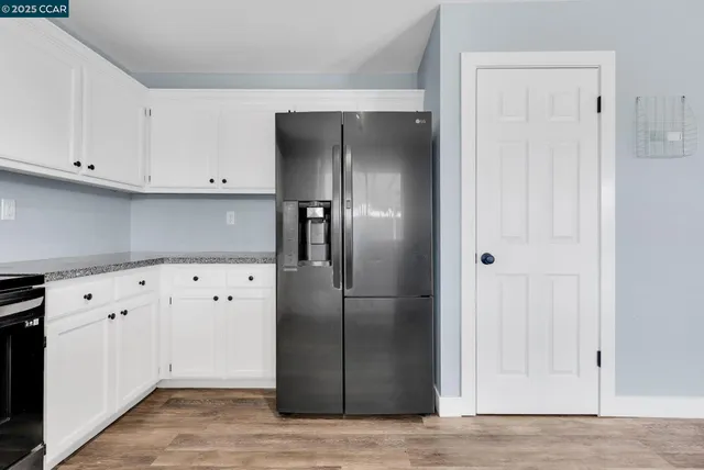 a kitchen with granite countertop cabinets and refrigerator