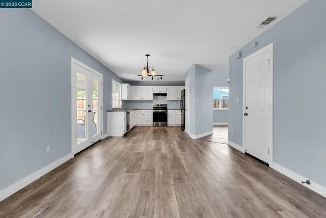 a view of a kitchen with wooden floor electronic appliances and window
