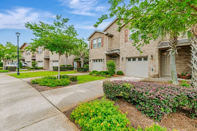 a front view of a house with a yard and potted plants