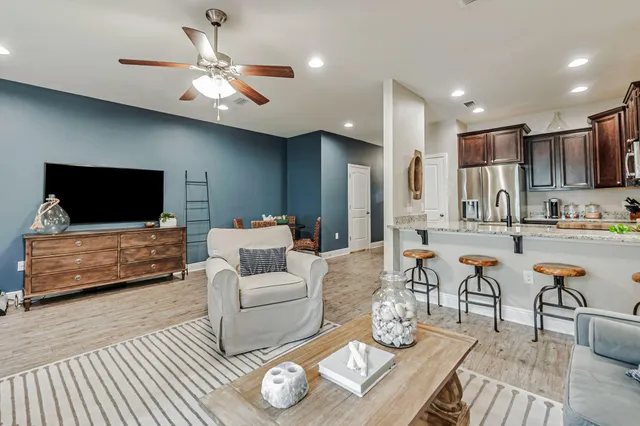 a living room with furniture kitchen view and a flat screen tv