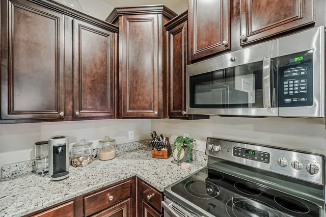 a kitchen with granite countertop a sink and stainless steel appliances
