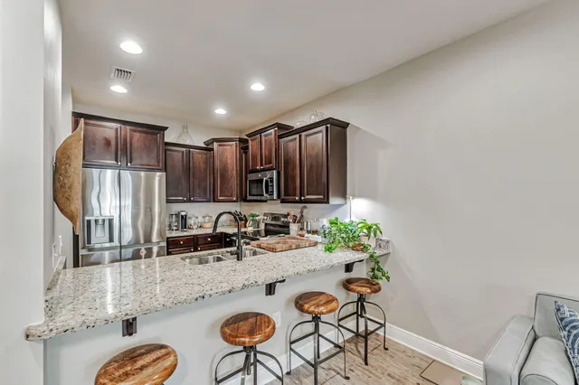 a kitchen with stainless steel appliances granite countertop a sink and a refrigerator